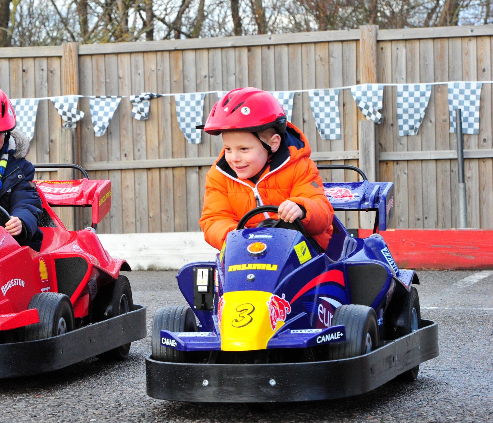Children in helmets lined up in karts