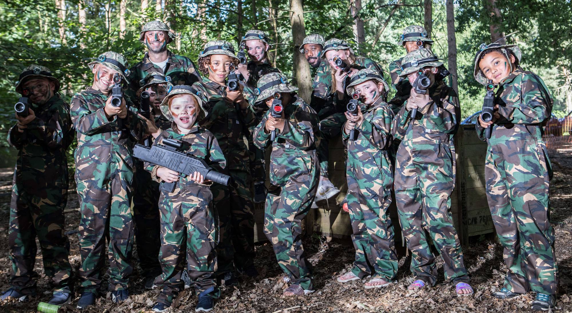 Laser Warfare player in camouflage aiming through the trees